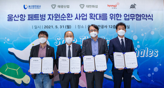 태광산업과 대한화섬은 지난달 31일 울산시 남구 울산항만공사 12층 전망대에서 해양 플라스틱 자원순환 사업을 위해 울산항만공사, 우시산, 형지엘리트와의 업무협약을 체결했다. 사진은 왼쪽부터 우시산 변의현 대표, 고상환 울산항만공사 사장, 박재용 태광산업 섬유사업본부 대표이사, 노길주 형지엘리트 총괄본부장이 기념촬영을 하고 있는 모습. <태광산업 제공>